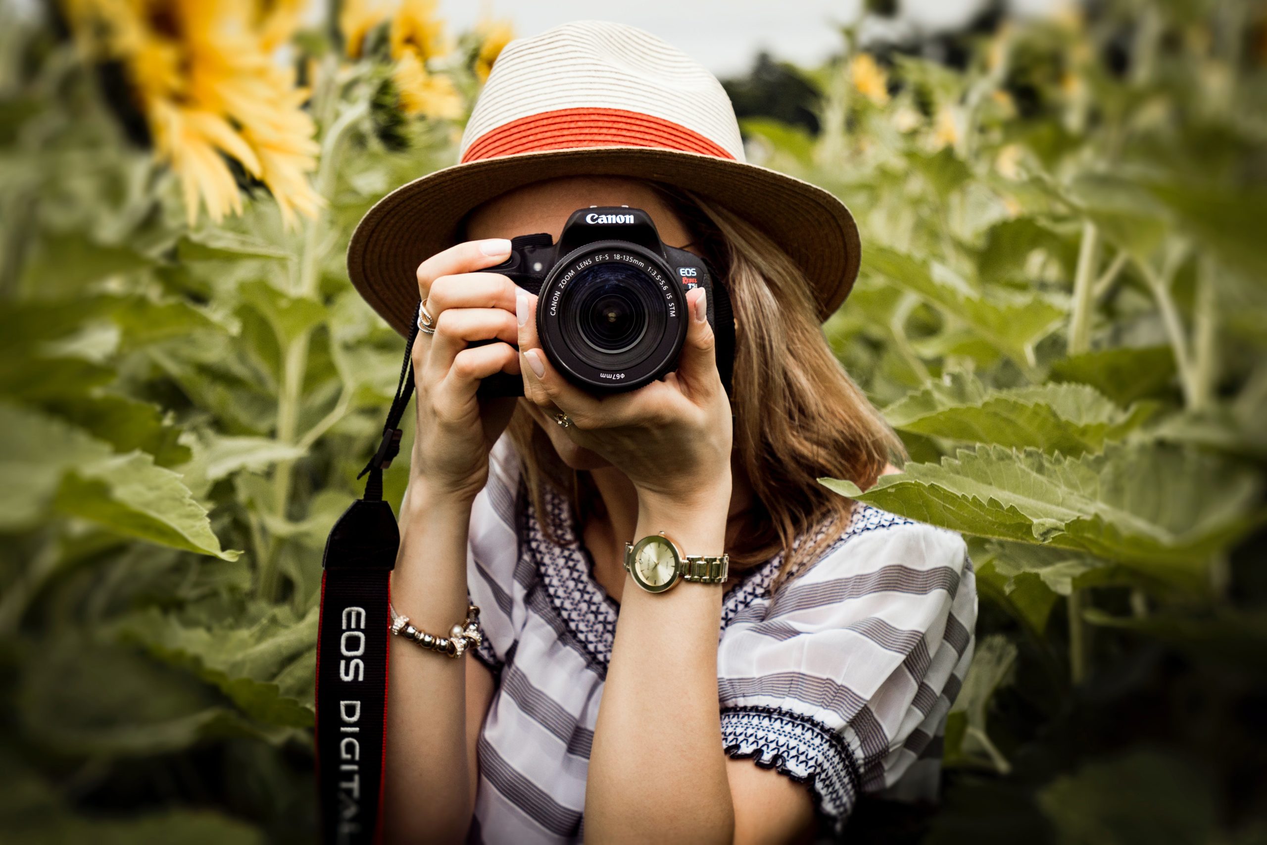 Mujer joven tomando foto con cámara Canon